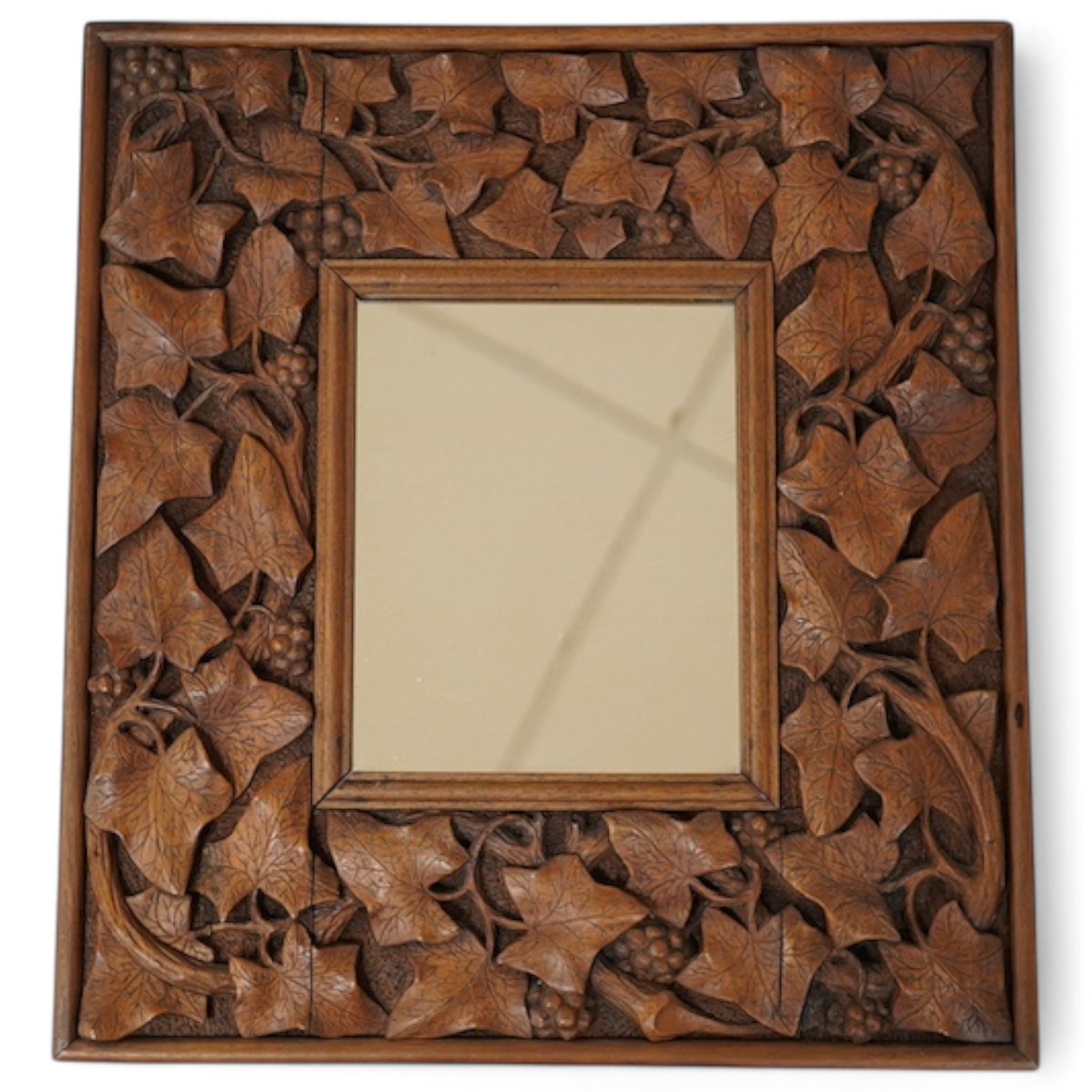 An early 20th century carved mahogany 'leaf, vine and berry' framed mirror, 41x38cm. Condition - good